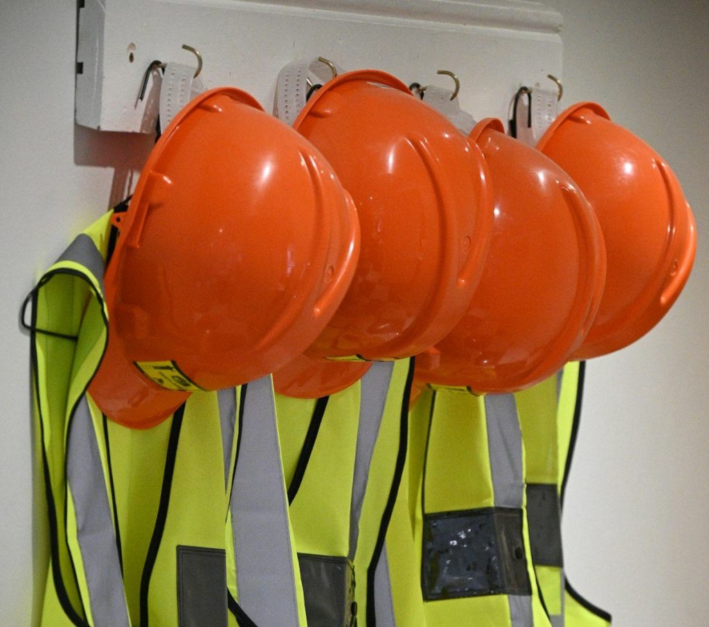 Caschi e gilet di sicurezza appesi, dispositivi di protezione individuale