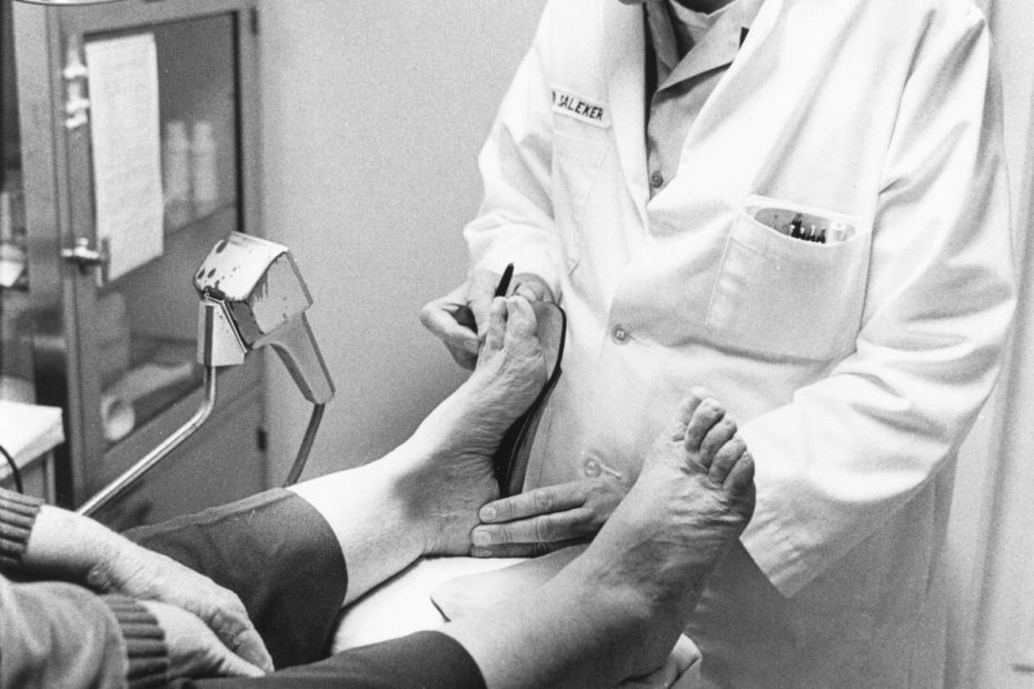 Medico che esamina il piede e la caviglia di un paziente
